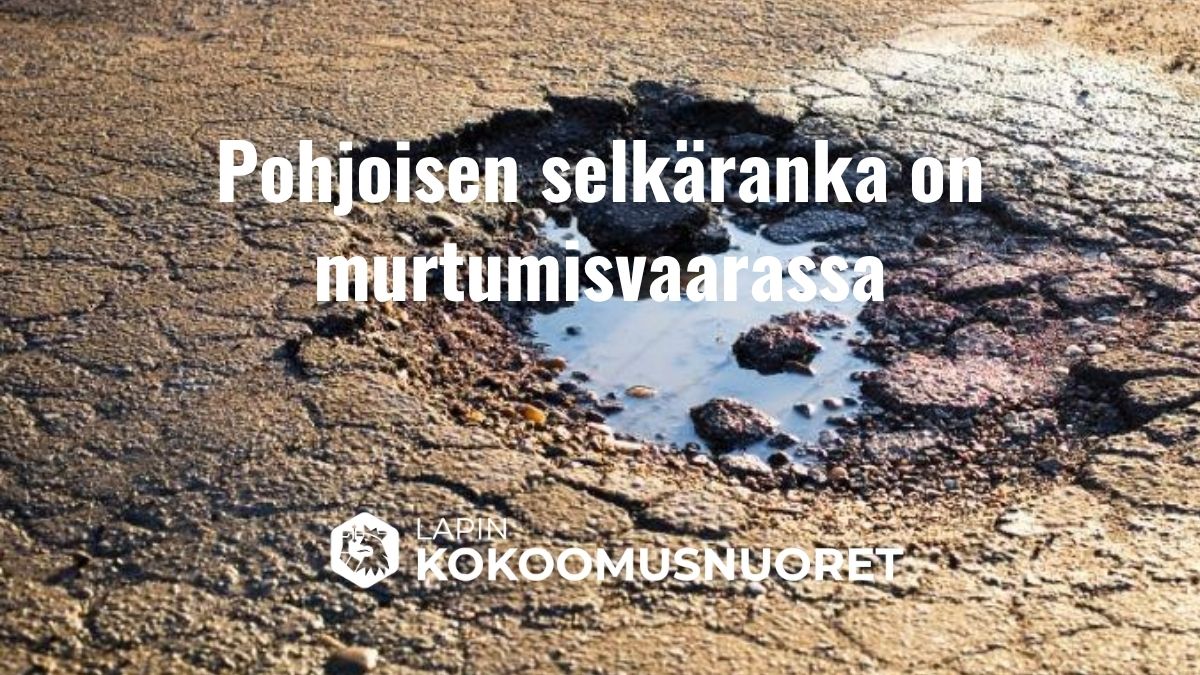 Kuvassa on kuoppainen ja huonokuntoinen tie, jossa näkyy suuri vesilammikon täyttämä kuoppa. Kuvan päällä lukee: ”Pohjoisen selkäranka on murtumisvaarassa”. Alareunassa lukee ”Lapin Kokoomusnuoret”.